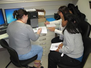 WSLH Chemist Marcy Rowe (left) reviews mass spec cutoff data for repeating and reporting testing with Ledith Resto Melendez (top right) and Zulley Peńaloza Medina.