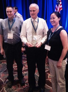 Philip Wegner and Pa Vang from the WI Division of Public Health TB Program flank Dr. Dave Warshauer, who’s holding his Ed Desmond TB Laboratorian of the Year award.