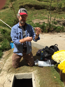 Dr. Pat Gorski sampling spring water in a buried cistern for coliform bacteria and E. coli testing.