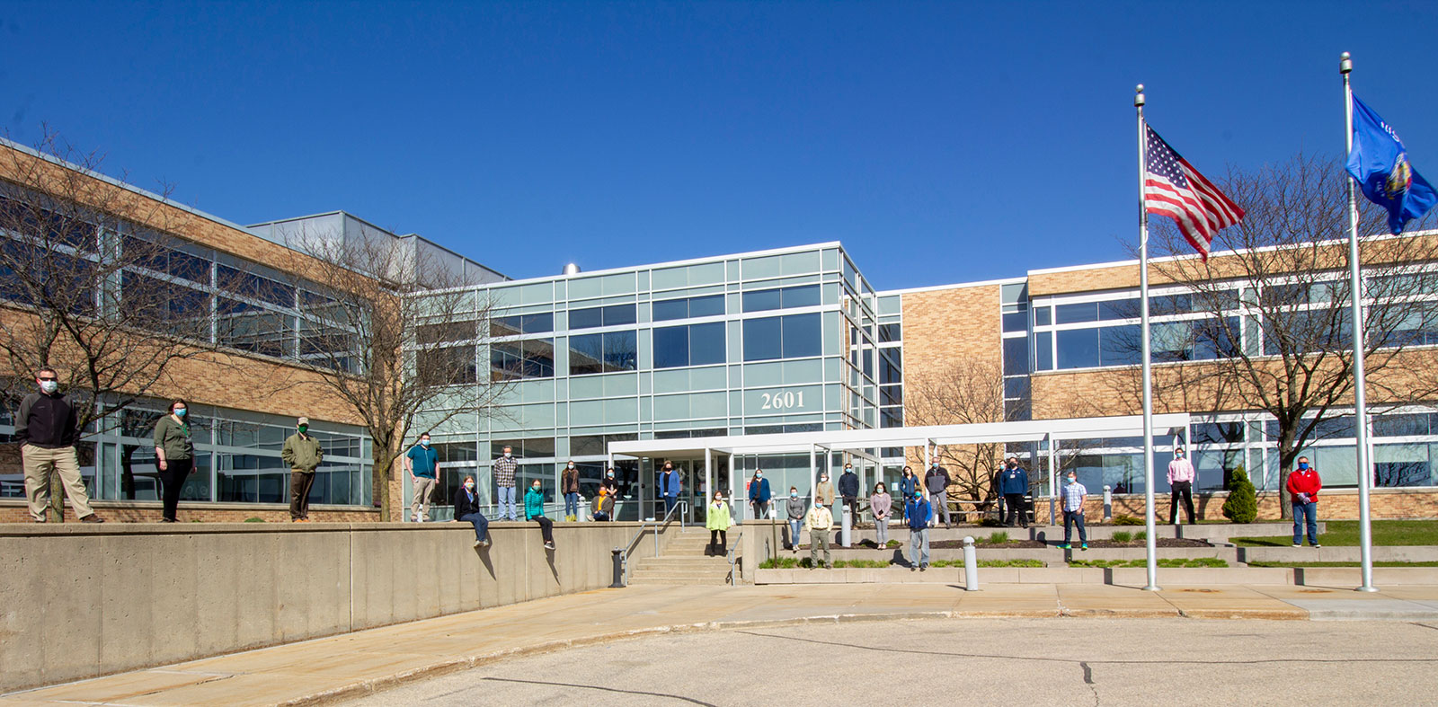 people spread out in front of Wisconsn State Laboratory of Hygiene building wearing face masks