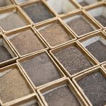 Multiple small square boxes holding dried and ground soil samples.