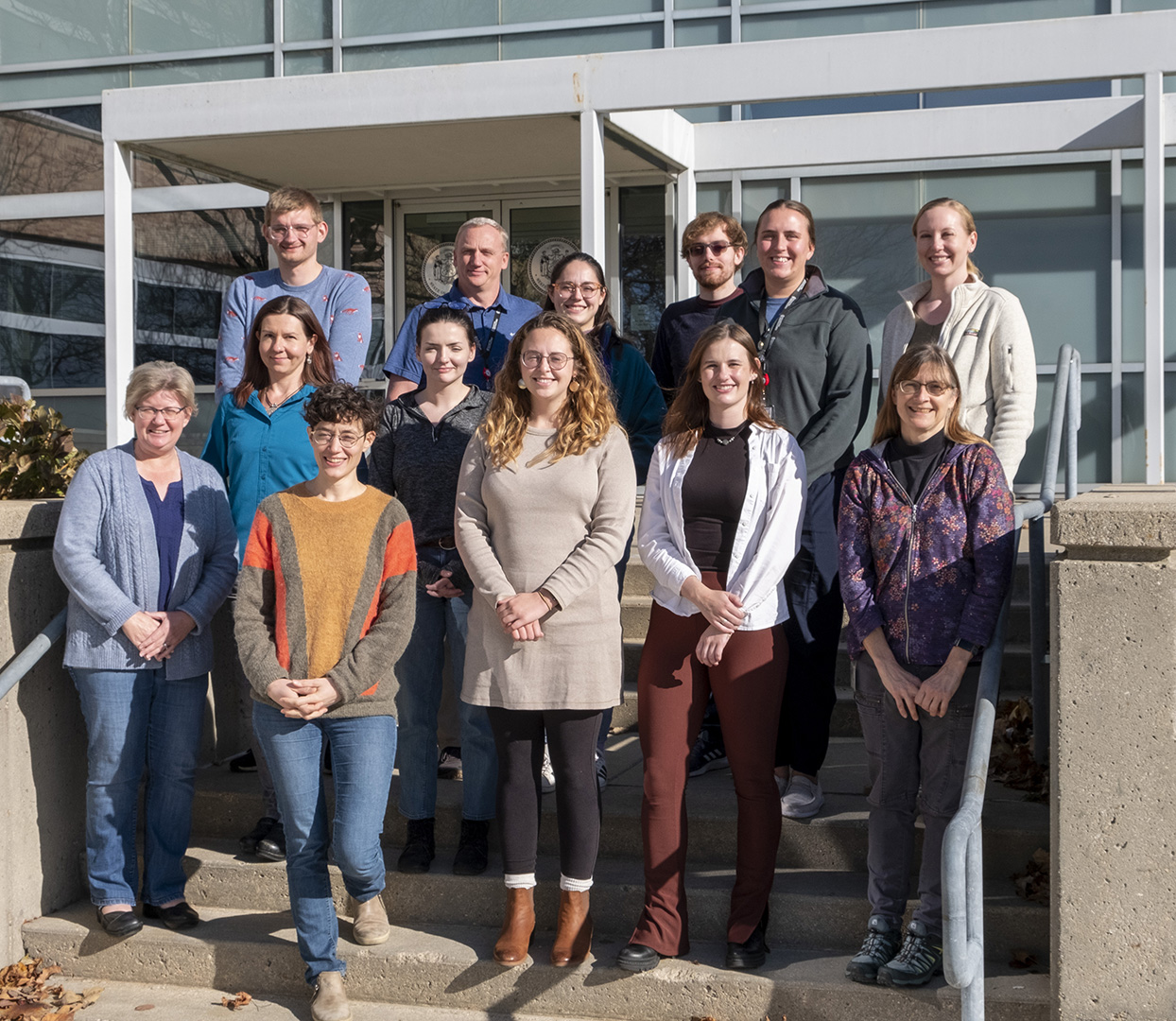 Photo of WSLH Wastewater Surveillance Team standing on steps in front of WSLH Agriculture Drive building in Madison, WI.