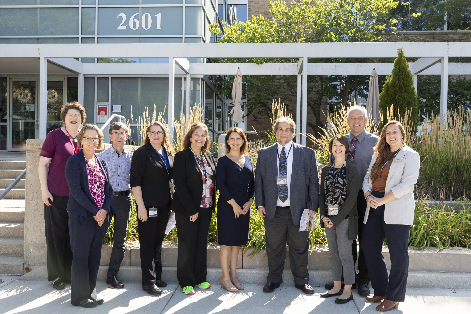 Gathered in front of the WSLH’s Agriculture Drive facility on Madison’s east side are from left: Jan Klawitter, Camille Danielson, Dr. Martin Shafer and Dr. Alana Sterkel with the WSLH, WI DHS Deputy Secretary Deb Strandridge, CDC Director Dr. Mandy Cohen, WSLH Director Dr. Jamie Schauer, WSLH Associate Directors Dr. Errin Rider and Steve Strebel, and Jean Brody, state director of outreach for WI Senator Tammy Baldwin.