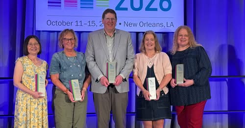 Four women and one man holding awards.